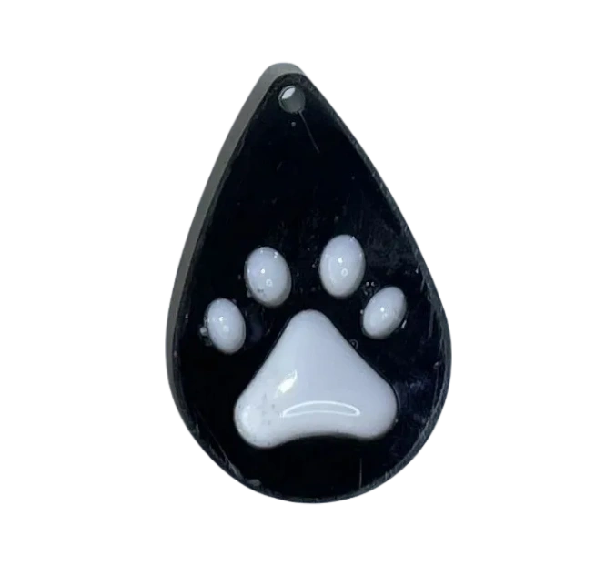 Small handmade black water drop-shaped charm with white paw