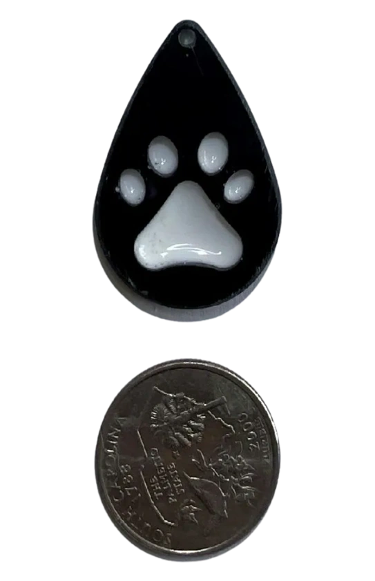 Small handmade black water drop-shaped charm with white paw